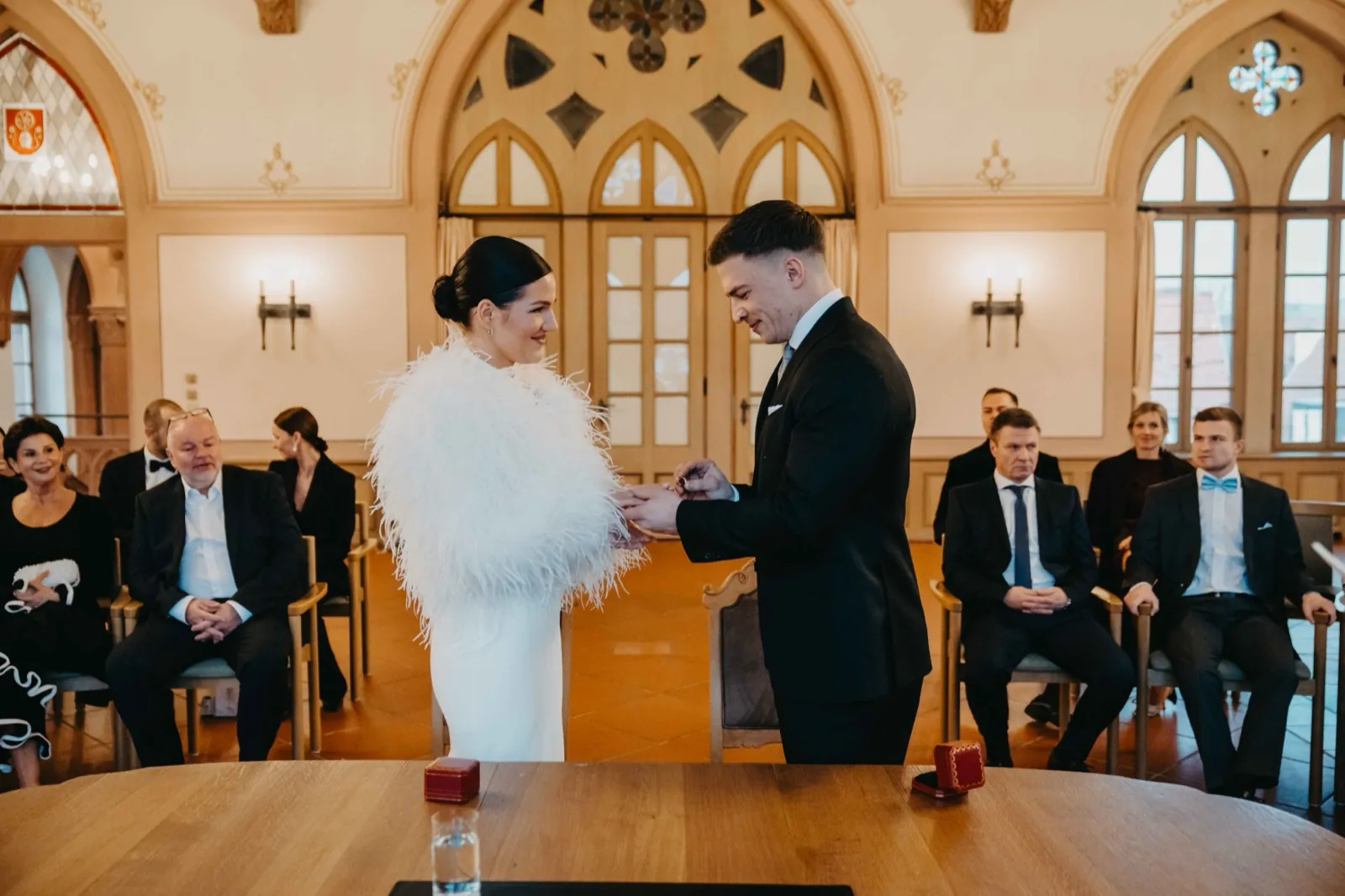 Alisa & Lars – Ein Brautpaar tauscht während der Hochzeitszeremonie im Beisein von Gästen die Ringe aus