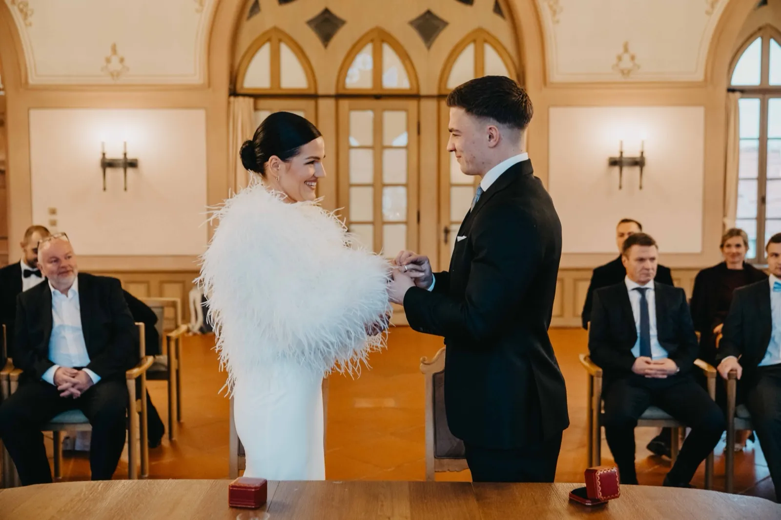 Alisa & Lars – Ein Brautpaar tauscht während der Hochzeitszeremonie im Beisein von Gästen die Ringe aus
