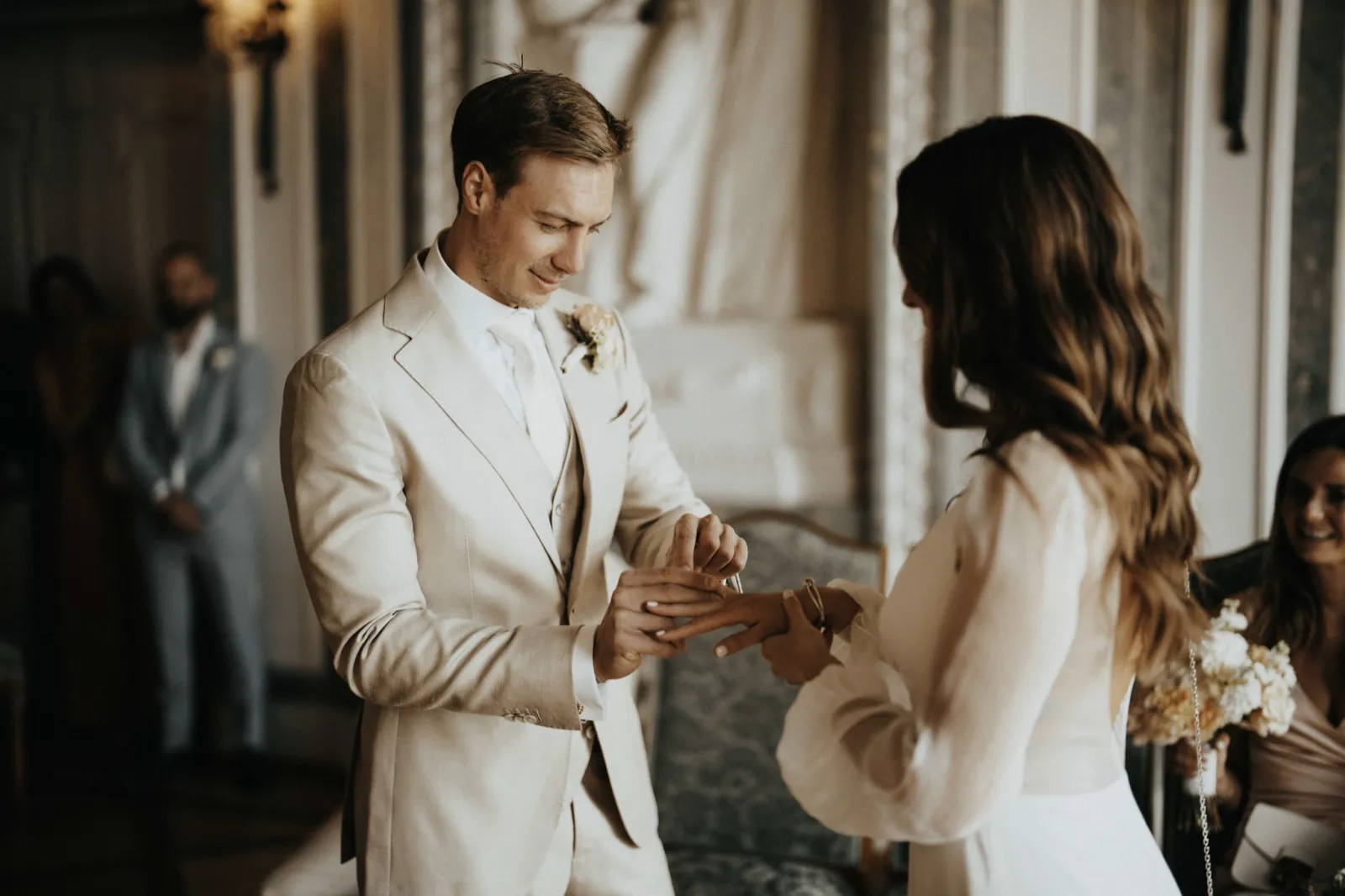 Deana & Sebastian – Der Bräutigam steckt der Braut während der Hochzeitszeremonie den Ring an den Finger