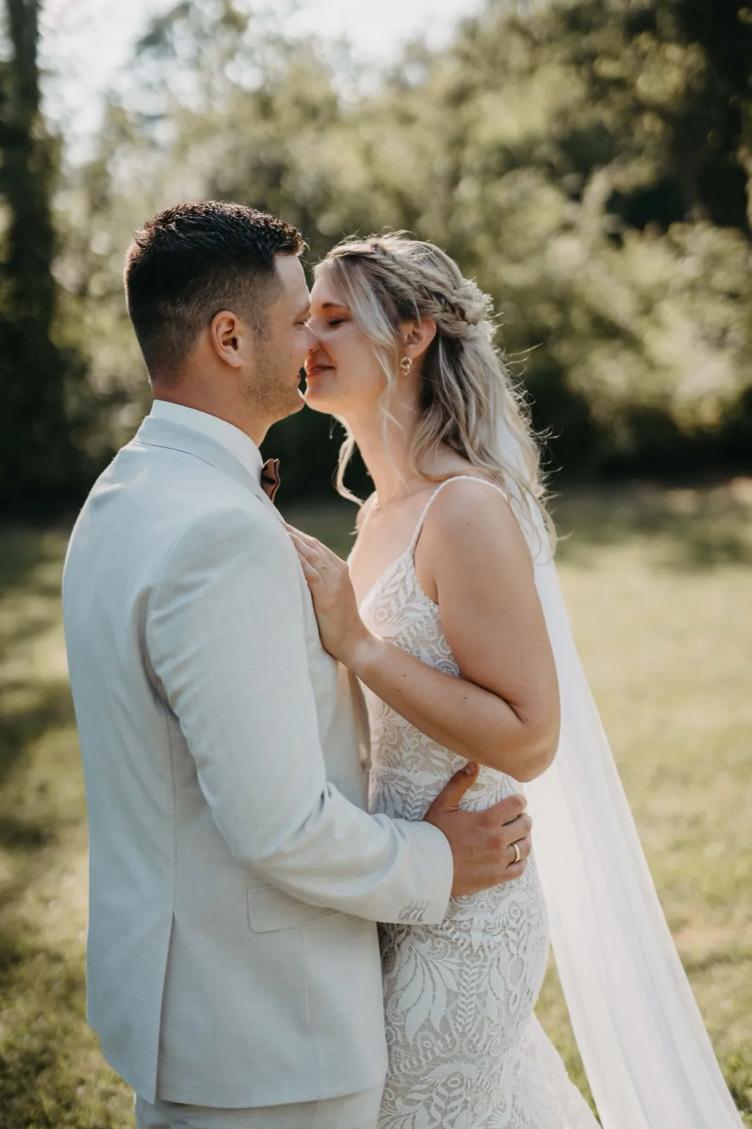 Jana & Christoph – Ein Brautpaar steht eng umschlungen im Freien und berührt sich zärtlich im Gesicht