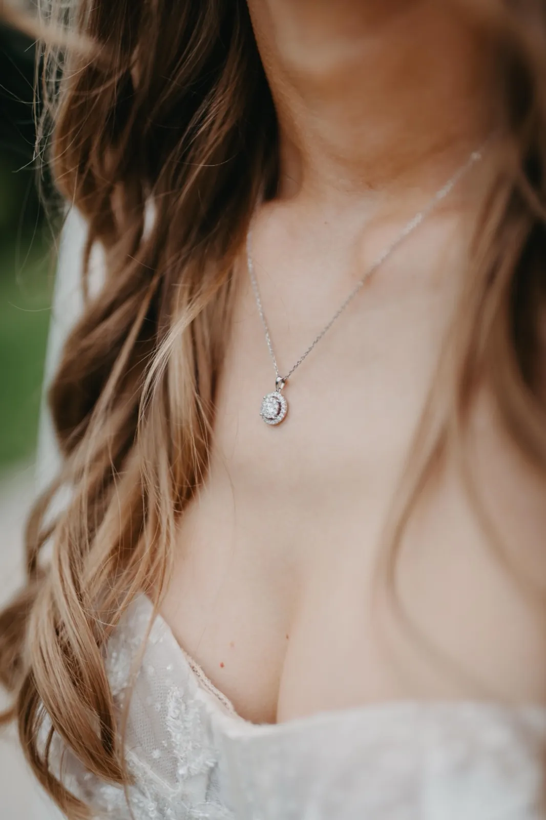 Jana & Murat – Nahaufnahme einer Braut mit einer silbernen Halskette und einem weißen Spitzenkleid