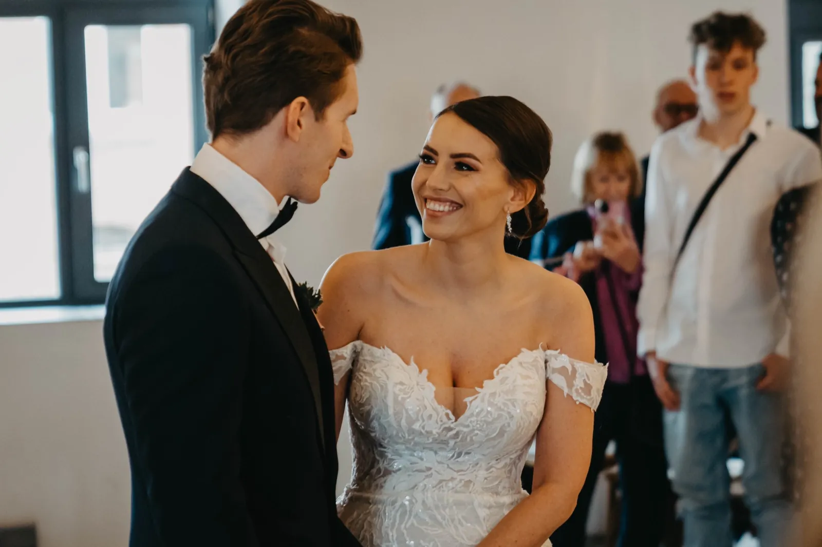 Julia & Florian – Braut und Bräutigam lächeln sich während der Hochzeitszeremonie glücklich an