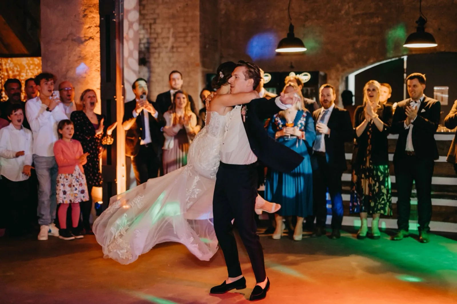 Julia & Florian – Ein Brautpaar tanzt ausgelassen auf der Tanzfläche, während die Hochzeitsgäste im Hintergrund zuschauen