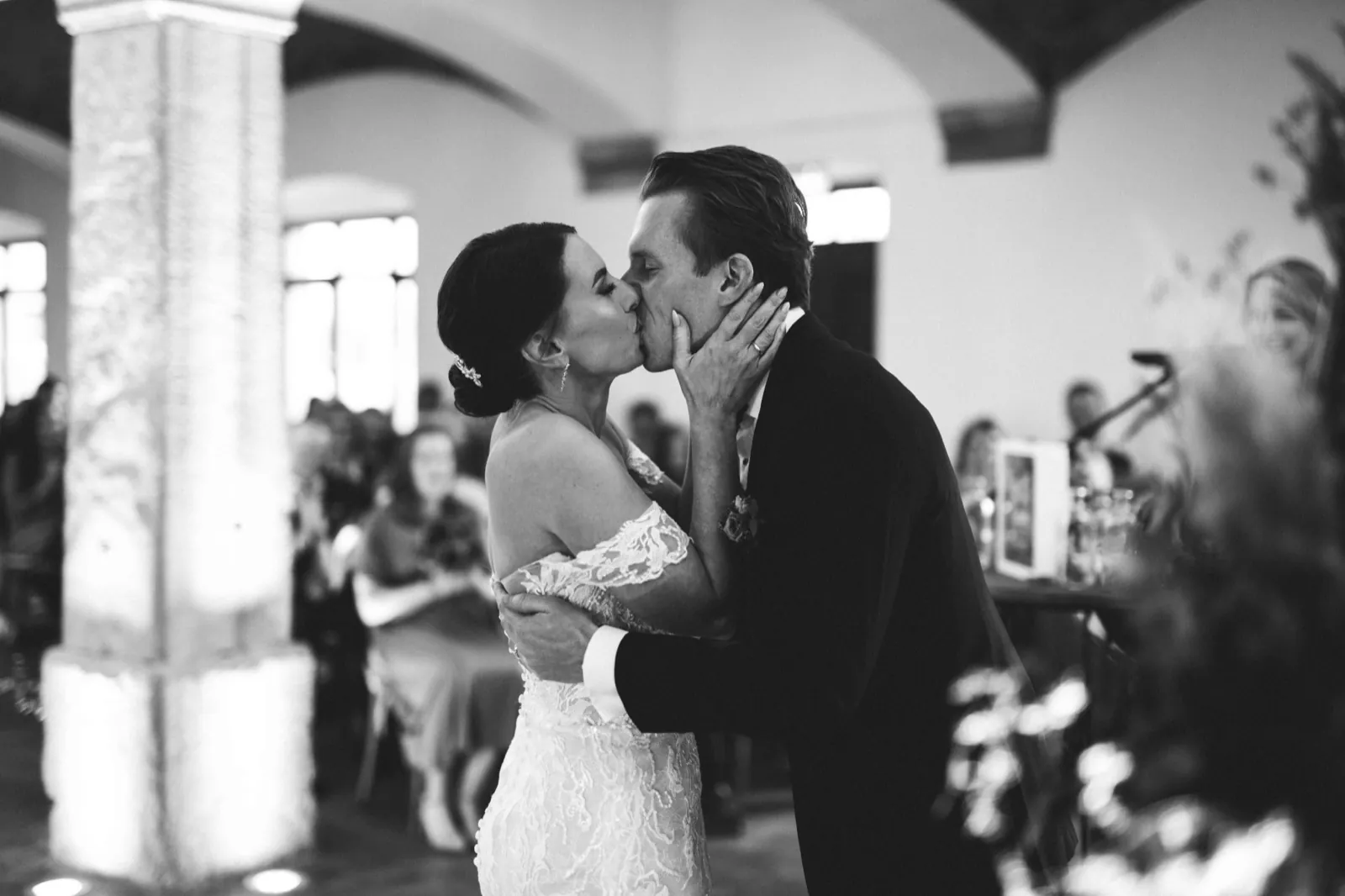 Julia & Florian – Ein Brautpaar küsst sich innig während der Hochzeitszeremonie in einem Innenraum