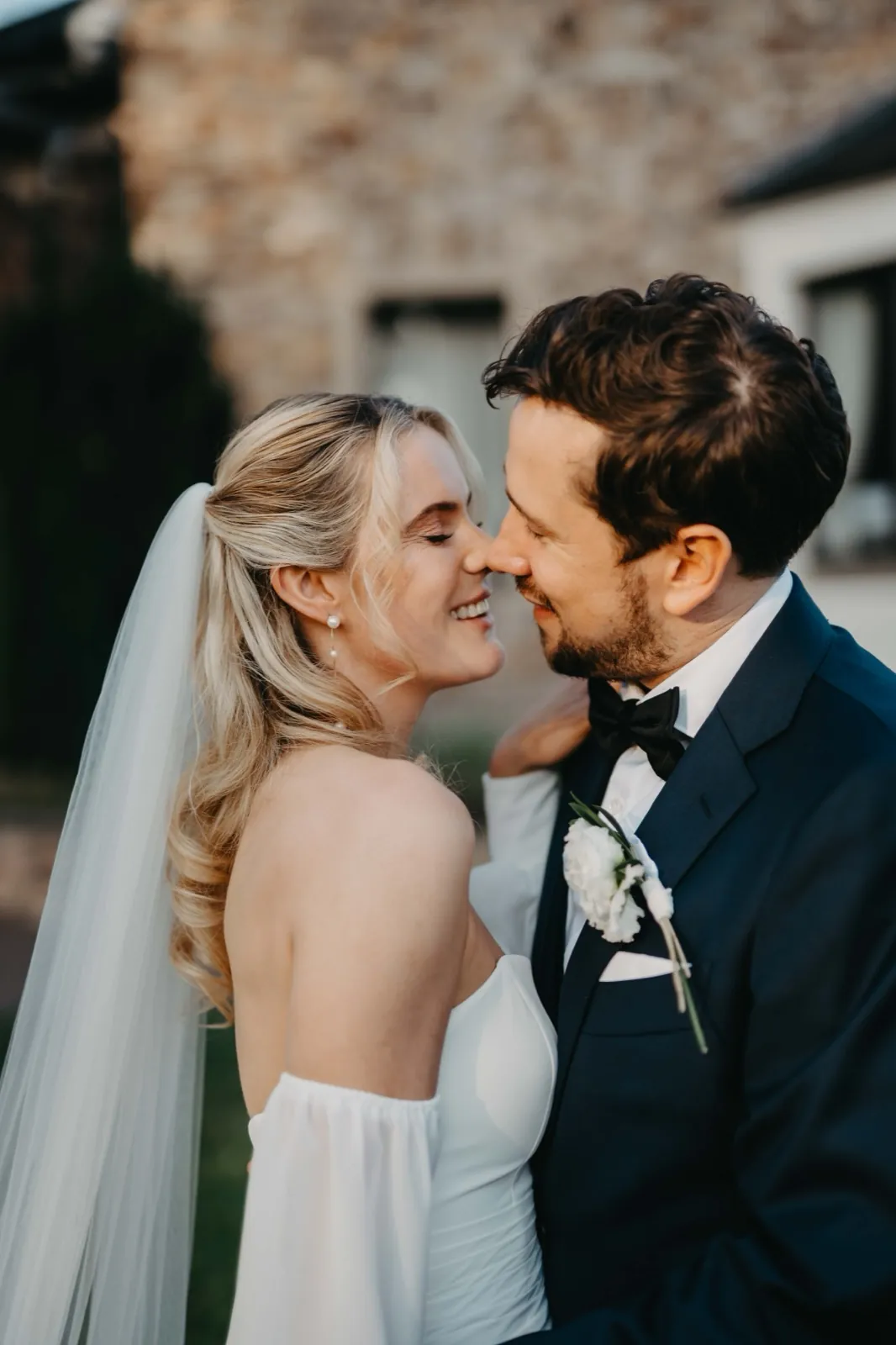 Julia & Max – Ein Brautpaar steht eng beieinander und lächelt sich glücklich an